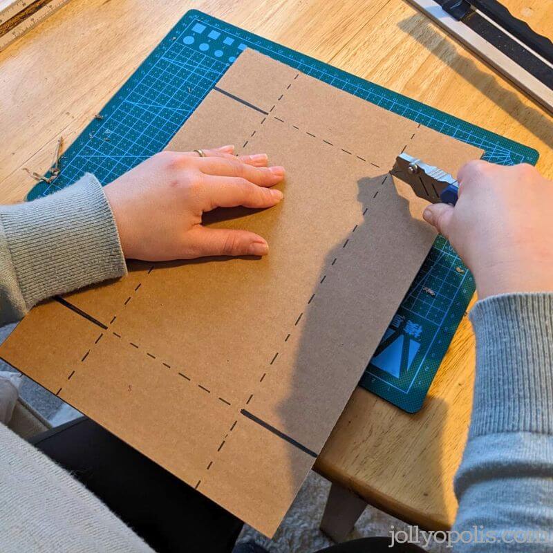 Cutting out the cardboard box template with a craft knife