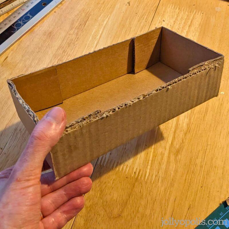 Pressing the flaps into place to form the cardboard box half